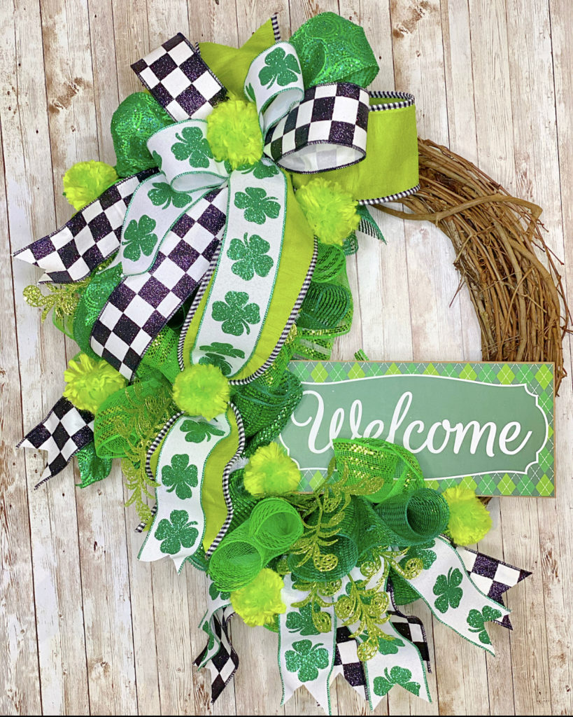 grapevine wreath with green decorations and welcome sign