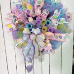 Evergreen wreath with pastel colored deco mesh and fake donuts and cake pops