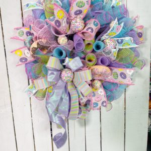 Evergreen wreath with pastel colored deco mesh and fake donuts and cake pops
