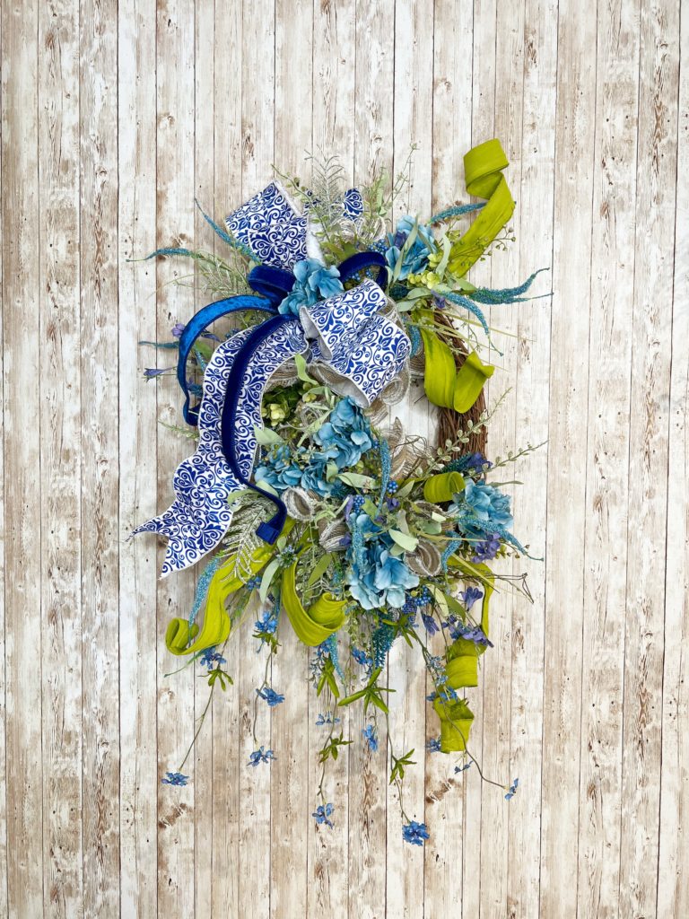 grapevine with greenery and blue florals and ribbon