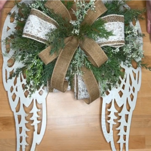 metal angel wings with greenery stems and a bow