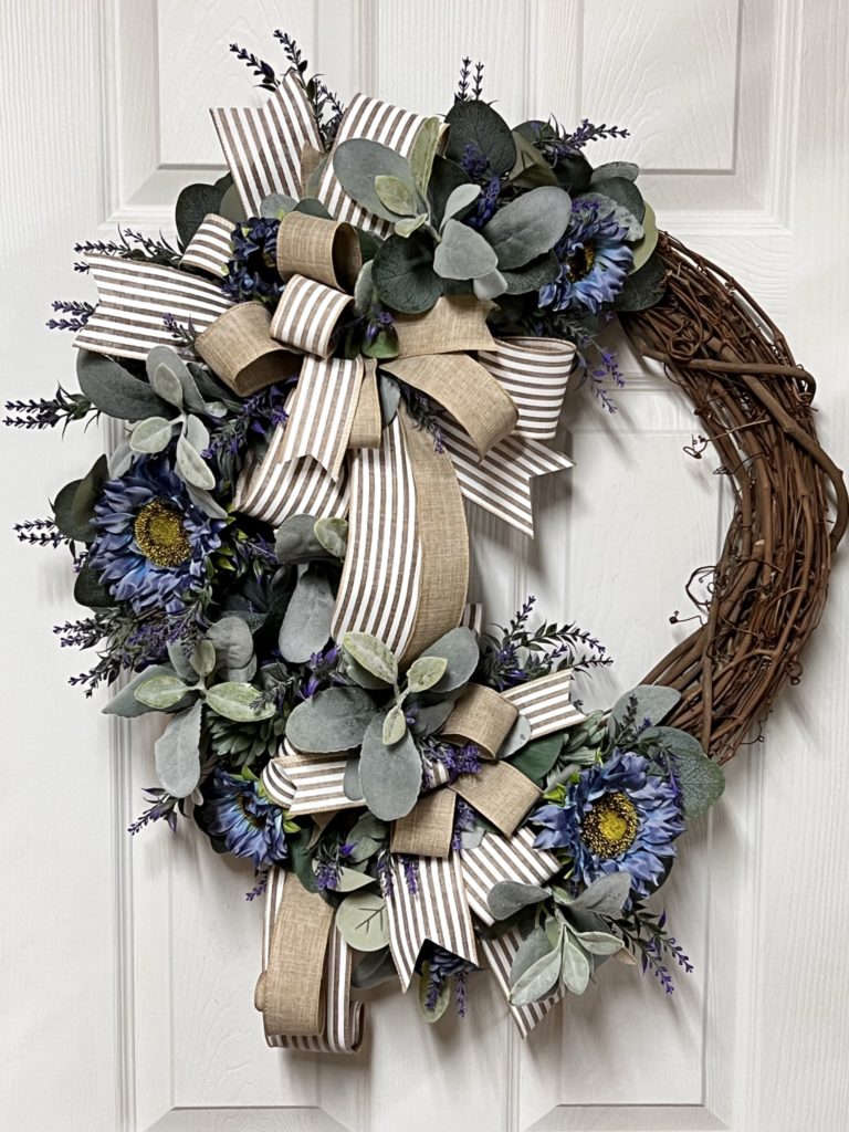 grapevine wreath with periwinkle sunflowers and greenery